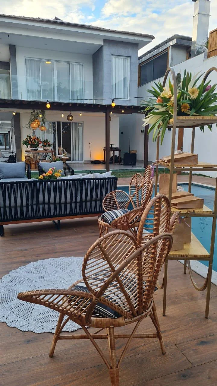 Poltrona de rattan no deck de madeira ao lado da piscina